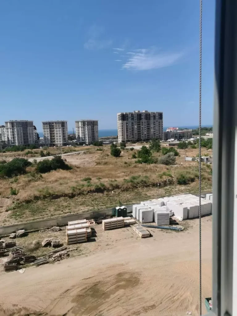 Вид из окна ЖК "АВАнта" (AVAnta) на стройплощадку, рядом стоящие здания и на море 